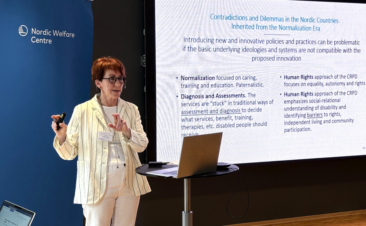 Rannveig Traustadottir speaking in a conference room