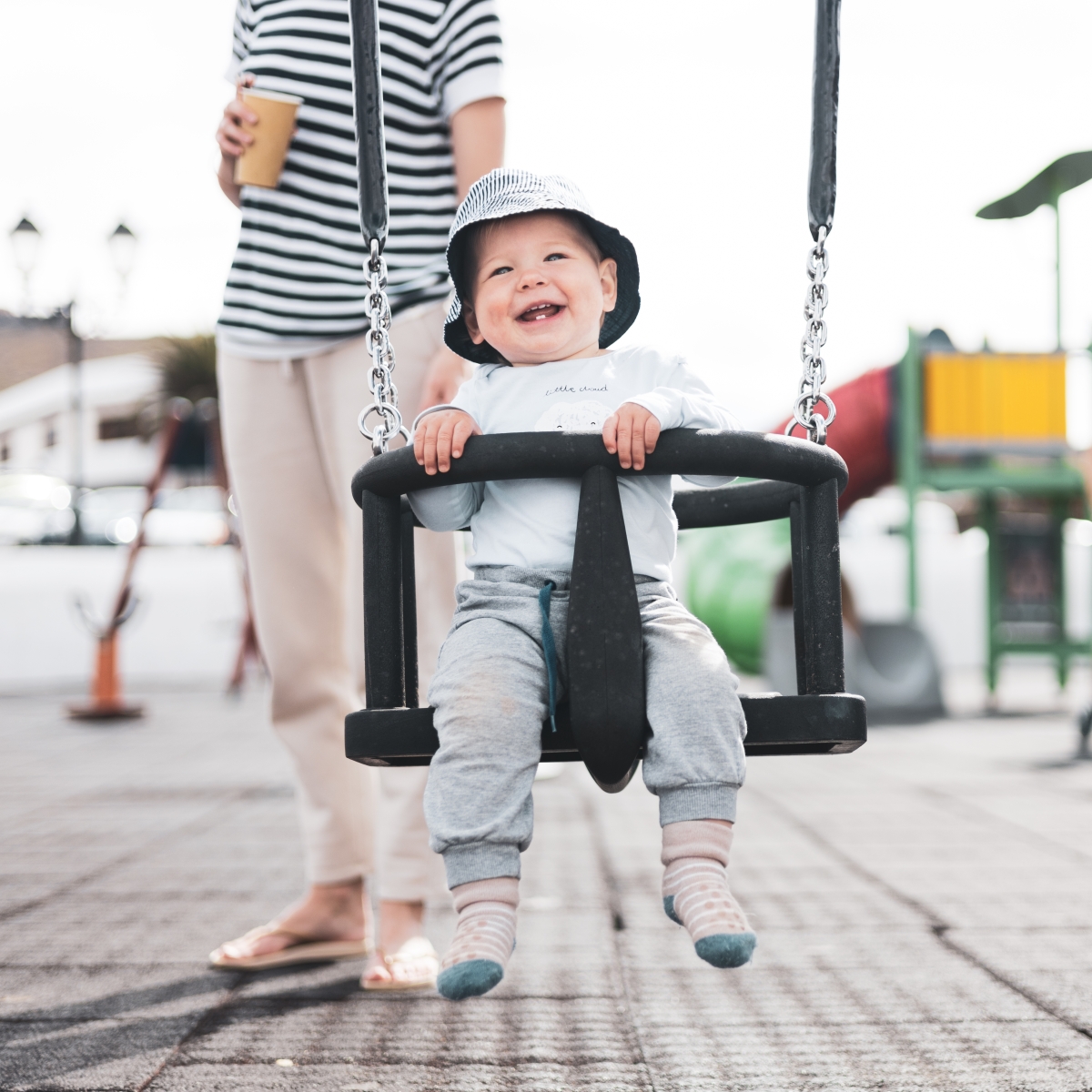 Mother pushing a child in a swing
