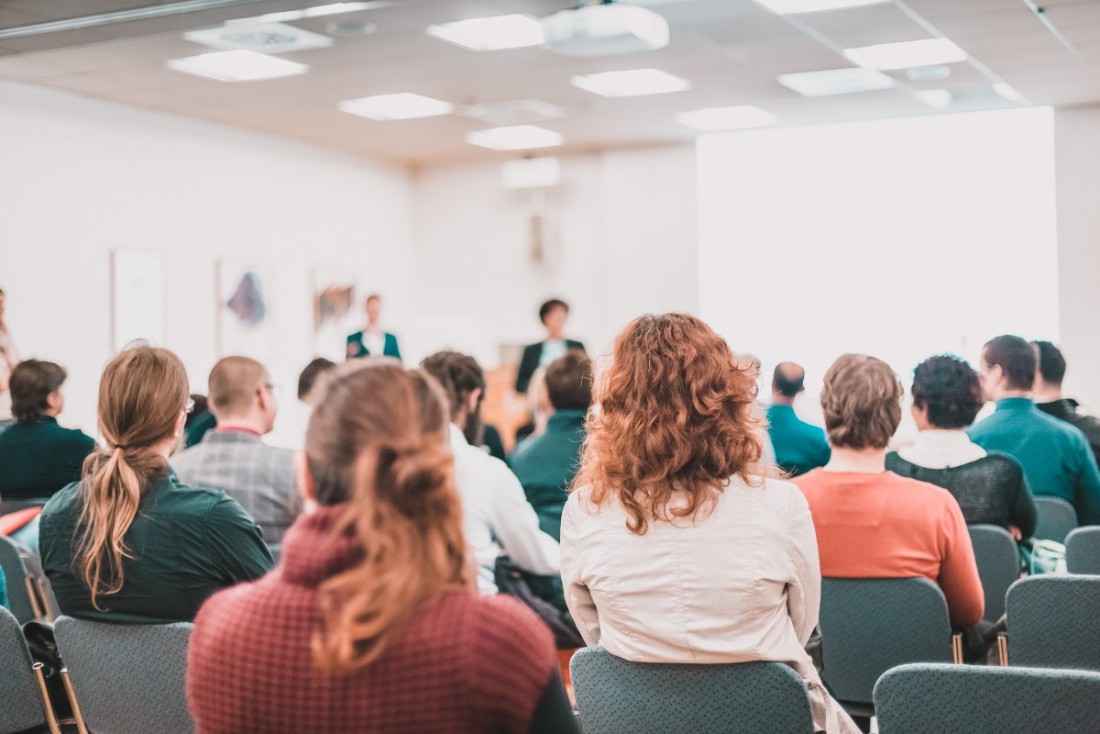 Publik som lyssnar på två talare på scen