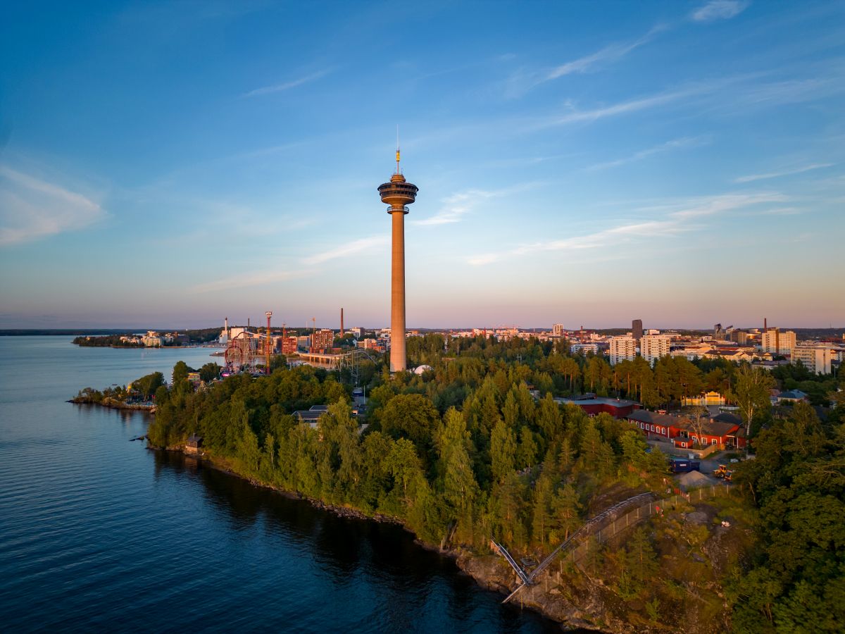 Luftfoto av Tampere i Finland, med Näsinneula-observasjonstårnet, frodig grøntområde og bygninger ved innsjøen