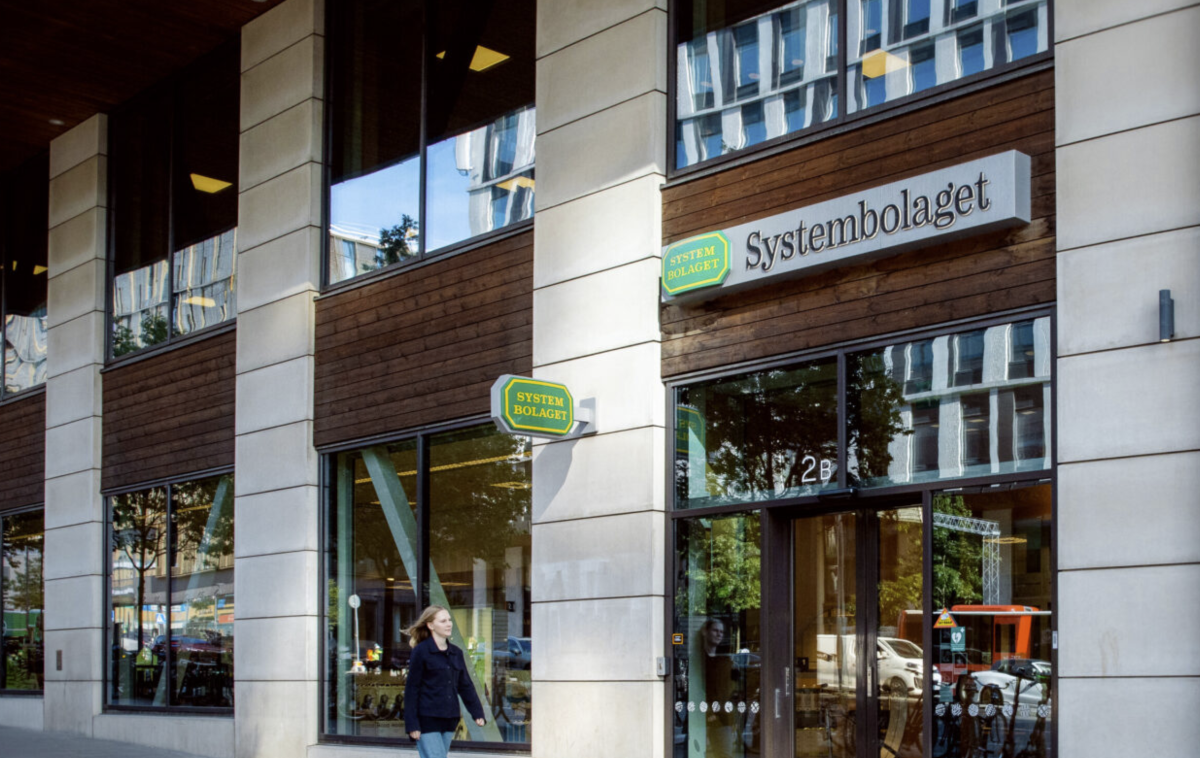 Kvinna promenerar förbi Systembolaget